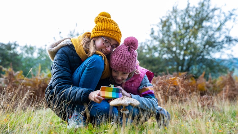 Girl taking pictures on a phone at Sutton Hoo, Suffolk
